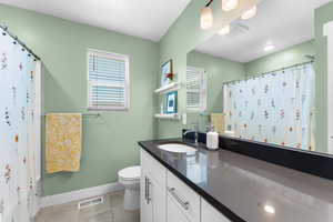 Bathroom featuring vanity, tile patterned flooring, and curtained shower
