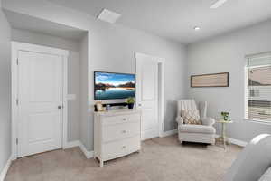 Living area featuring light colored carpet and recessed lighting
