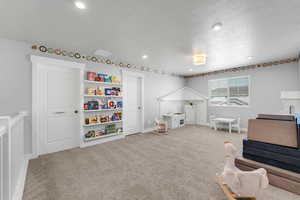 Playroom featuring carpet, a textured ceiling, and recessed lighting