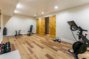 Exercise area featuring recessed lighting and light wood-type flooring