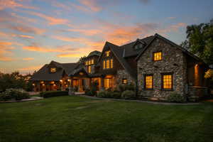 View of front facade featuring stone siding, a front lawn, and covered porch