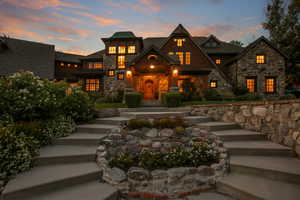 View of front of property with stone siding and stairs