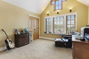 Office area featuring healthy amount of natural light, carpet flooring, baseboards, and high vaulted ceiling