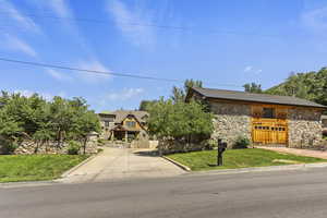 View of front facade featuring stone siding and concrete driveway