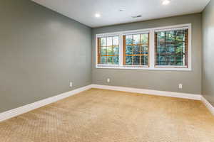 Empty room with carpet, a textured ceiling, and recessed lighting