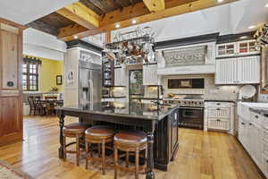 Kitchen with appliances with stainless steel finishes, dark countertops, a sink, light wood-style flooring, and recessed lighting