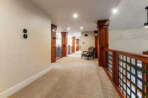 Hall with light carpet and recessed lighting