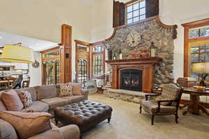Carpeted living room with a high ceiling and a glass covered fireplace