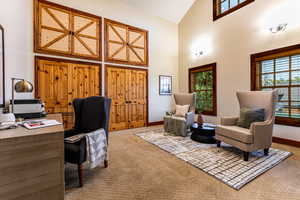 Office featuring high vaulted ceiling and light colored carpet