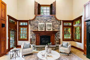 Living room with a textured wall, a high ceiling, and a fireplace