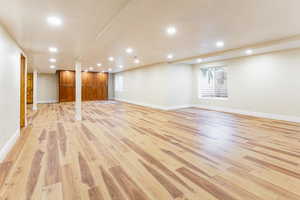 Basement with light wood-type flooring and recessed lighting