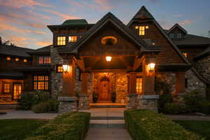 Doorway to property featuring covered porch and stone siding