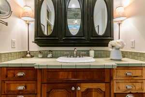 Bathroom featuring vanity and backsplash