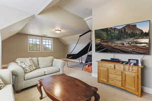 Living room featuring lofted ceiling, light colored carpet, and baseboards
