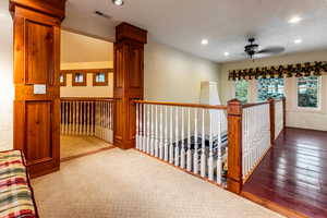 Hallway with a textured wall, recessed lighting, and light wood-type flooring