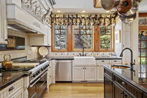 Kitchen featuring stainless steel appliances, a sink, custom range hood, tasteful backsplash, and recessed lighting