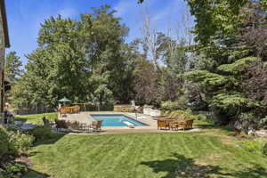 Swimming pool with a diving board, a playground, and a patio area