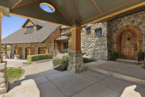 View of front of home with stone siding and covered porch