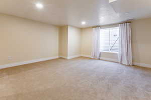 Spare room with light colored carpet, recessed lighting, and a textured ceiling