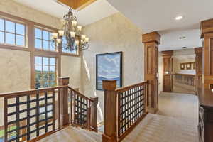 Stairway with a chandelier, a textured wall, carpet, and recessed lighting