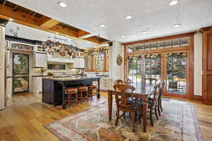 Dining room featuring light wood finished floors, a textured ceiling, and recessed lighting