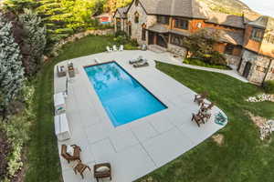 Swimming pool with a yard and a patio area