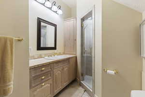 Bathroom featuring vanity, a shower stall, and tile patterned floors