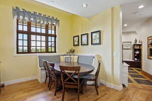 Dining space with wood finished floors, baseboards, and recessed lighting