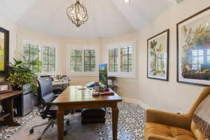 Office space with lofted ceiling, baseboards, and a chandelier