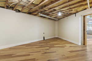 Below grade area featuring light wood-style flooring and baseboards