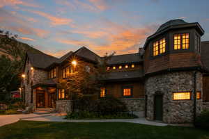 View of front of house with stone siding and a lawn