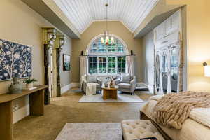 Carpeted bedroom featuring lofted ceiling, a chandelier, and wood ceiling