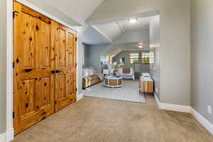 Living area featuring vaulted ceiling and light colored carpet