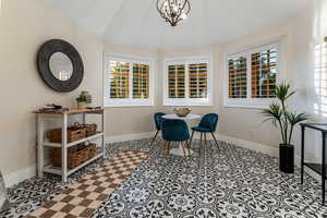 Dining area with vaulted ceiling, plenty of natural light, and a chandelier