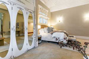 Carpeted bedroom with wood ceiling, arched walkways, and two closets