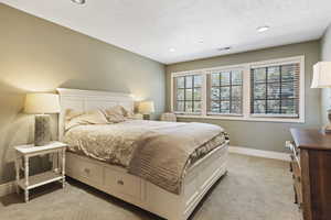 Bedroom with light carpet, a textured ceiling, baseboards, and recessed lighting