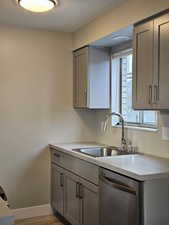 Kitchen featuring gray cabinets, dishwasher, and light hardwood / wood-style floors