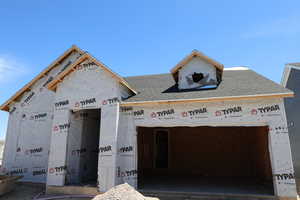 Unfinished property featuring roof with shingles
