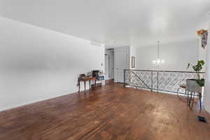 Spare room with a chandelier and wood finished floors