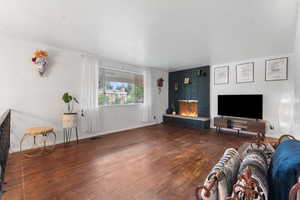 Living area featuring wood finished floors and a brick fireplace