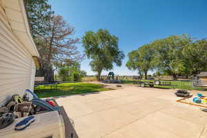 View of patio with a trampoline and a playground