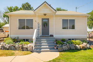View of front facade with a shingled roof and a front yard