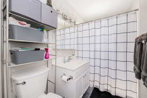 Bathroom with vanity, tile walls, tile patterned floors, and a shower with shower curtain