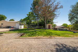 View of yard with a storage unit, a trampoline, and a fire pit