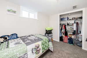 Carpeted bedroom with a closet and baseboards