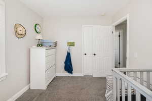 Carpeted bedroom with baseboards and a closet