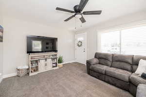 Living area featuring carpet floors and a ceiling fan