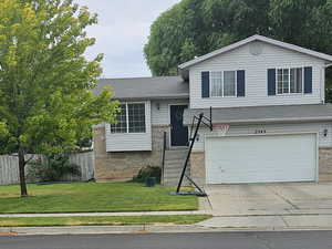 View of front of house featuring an attached garage, driveway, and brick siding