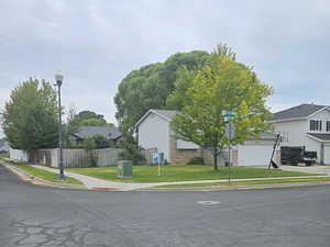 View of asphalt street with street lights, curbs, sidewalks, and a residential view
