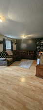 Living room with a textured ceiling and wood finished floors